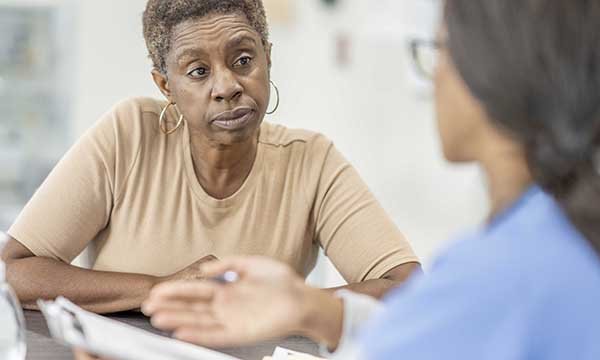 A nurse talks to a woman in the emergency department: skillful patient assessment forms the basis of triage