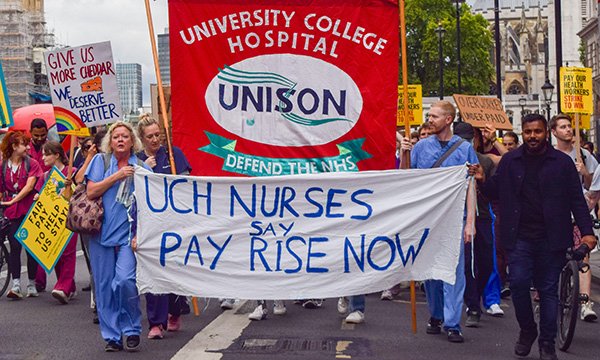 Healthcare workers carrying pay protest banners march on Downing Street in July 2022