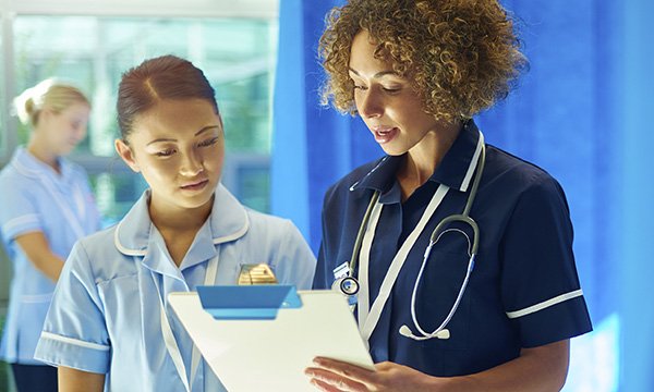 Photo of nursing student with nurse, illustrating story about student survey