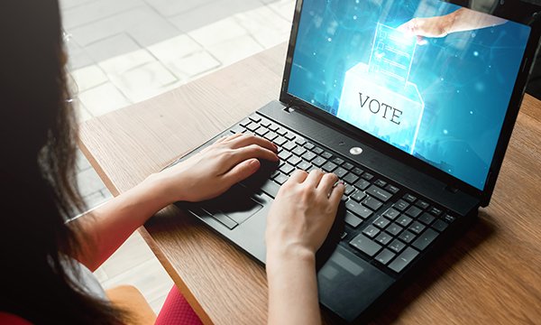 Close-up of a nurse's hands on a computer keyboard with a screen displaying X and tick marks to indicate 'unacceptable' or 'acceptable'