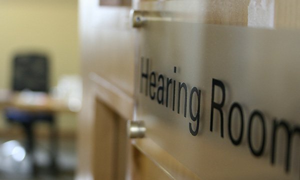 Nurse struck off for falsifying timesheets: photo shows a close-up of a fitness-to-practise hearing room door