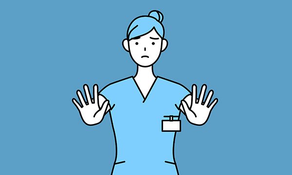 A nurse holds up her hands showing she wants something to stop. Nurses have a duty of care to patients but also need to consider their own safety