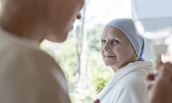 End of life care: a patient looking reassured as a nurse monitors their intravenous drip