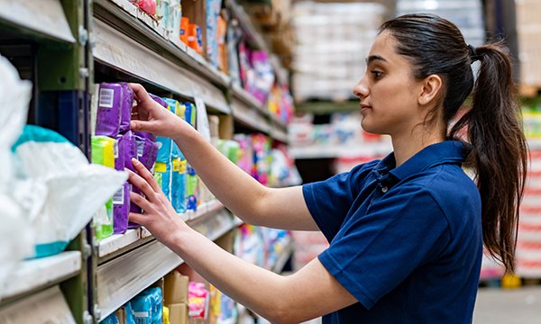 Nursing students working part-time in supermarkets: a young woman stacking shelves in a supermarket 