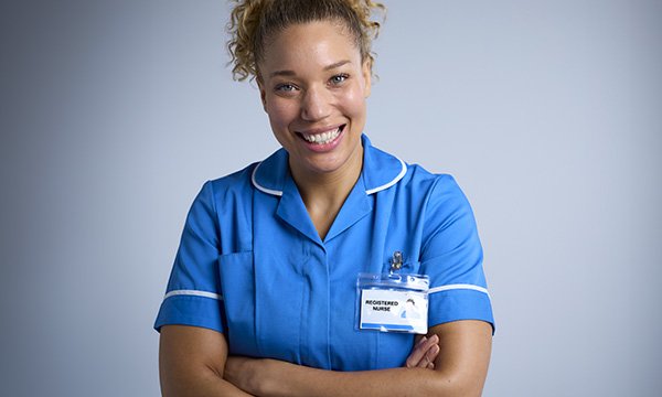 Protecting the nurse title: a nurse in uniform wearing a name tag and smiling at the camera