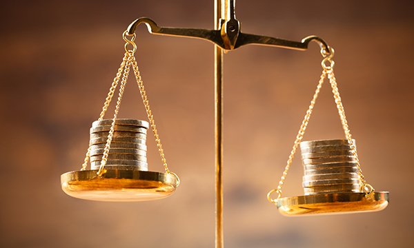 NHS pay inequality: weighing scales with pound coins on each side