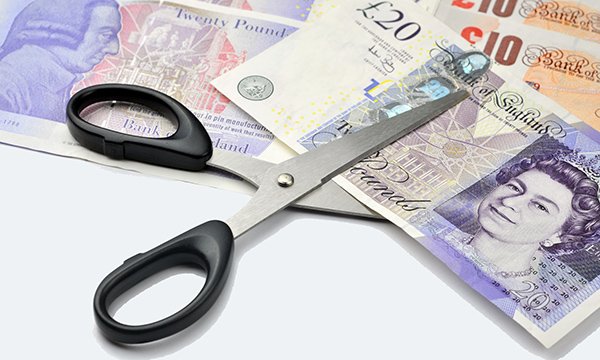 Bank shift pay cuts: scissors cut £20 notes in half to represent reduced pay rates that have angered nurses in north west England 
