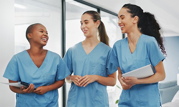 Peer support for nursing students: mentors can provide invaluable support; three nursing students looking happy together while on placement