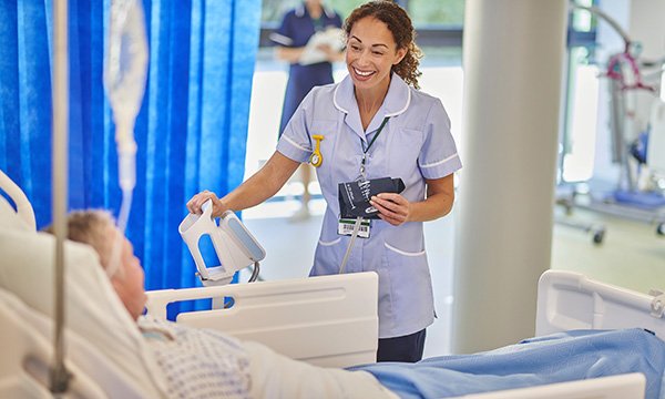 Nursing career choices: a smiling nurse talking to a patient on a hospital ward