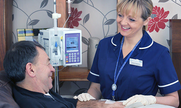 A nurse standing next to the bed of a patient