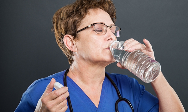 A nurse drinking from a bottle of water