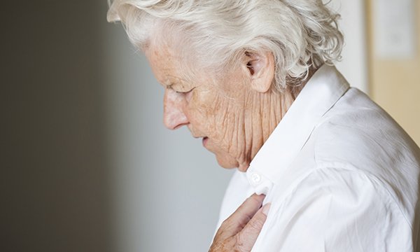 woman holds her chest