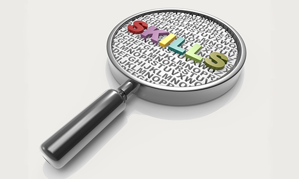 An illustration of a magnifying glass with "skills" written in the lens