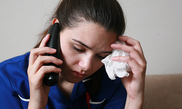 Nurse talking on the phone and looking stressed