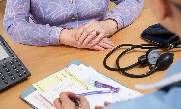 Nurse prescribing to a patient over a desk