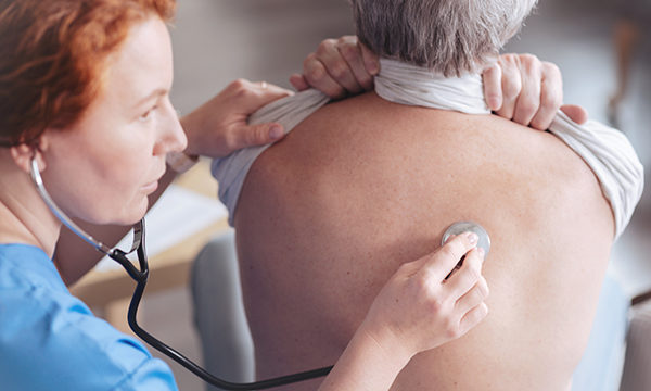 nurses listens to patient's lungs