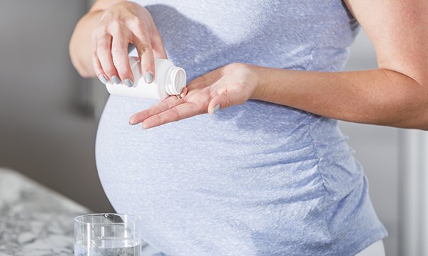 Pregnant_woman_taking_Pill