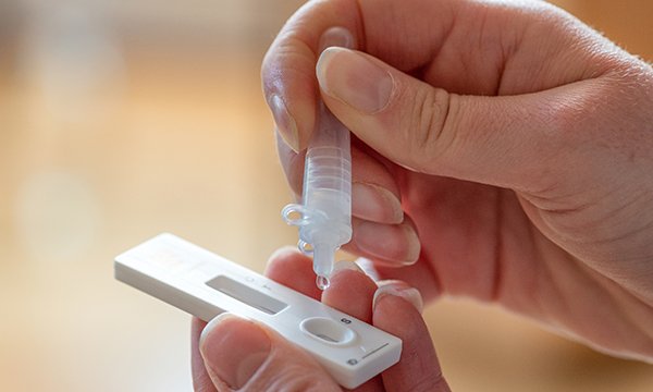 Picture of someone using a COVID-19 testing kit