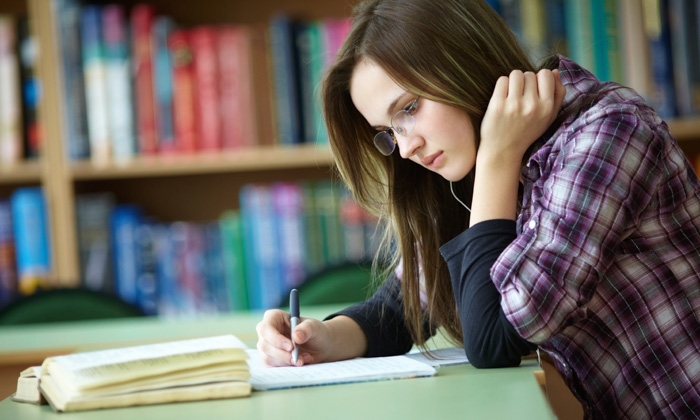 A woman in a library writing